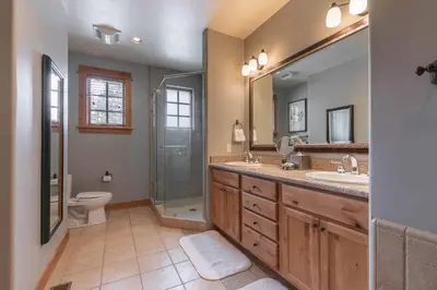 a bathroom with two sinks and a shower and a toilet at Fairway Drive 13113 by East West Hospitality in Truckee
