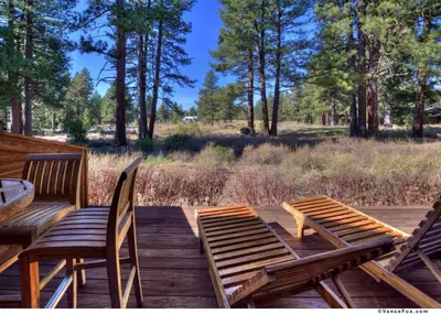 two chairs and a table on a wooden deck at Fairway Drive 13136 by East West Hospitality in Truckee