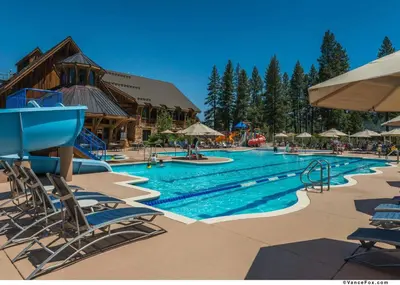 a large swimming pool with chairs and a resort at Fairway Drive 13136 by East West Hospitality in Truckee