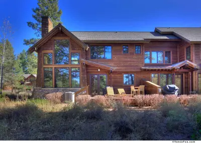 a large wooden house with glass windows at Fairway Drive 13136 by East West Hospitality in Truckee