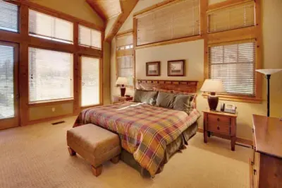 a bedroom with a bed and a desk and windows at Gold Rush Trail 12560 by East West Hospitality in Truckee