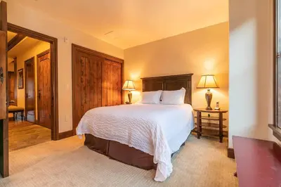 a bedroom with a large bed with white sheets at Great Bear Lodge 201 by East West Hospitality in Truckee