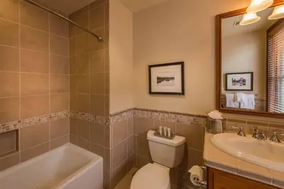 a bathroom with a tub and a toilet and a sink at Great Bear Lodge 306 by East West Hospitality in Truckee