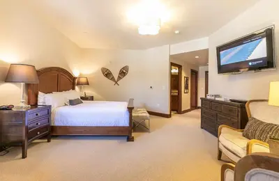 a bedroom with a bed and a flat screen tv at Great Bear Lodge 306 by East West Hospitality in Truckee