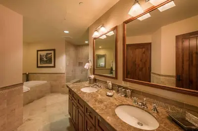 a bathroom with two sinks and a large mirror at Great Bear Lodge 306 by East West Hospitality in Truckee
