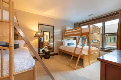 a bedroom with two bunk beds and a kitchen at Great Bear Lodge 302 by East West Hospitality in Truckee