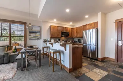 a kitchen with a refrigerator and a table and chairs at Iron Horse Lodge North 309 by East West Hospitality in Truckee