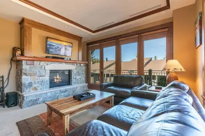 a living room with a couch and a fireplace at Iron Horse Lodge North 209 by East West Hospitality in Truckee