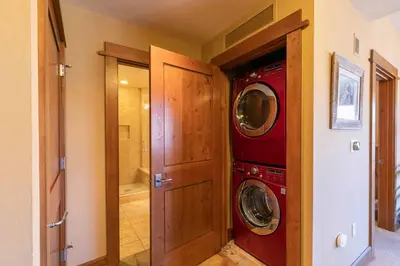 a laundry room with a washer and dryer next to a door at Iron Horse Lodge North 209 by East West Hospitality in Truckee