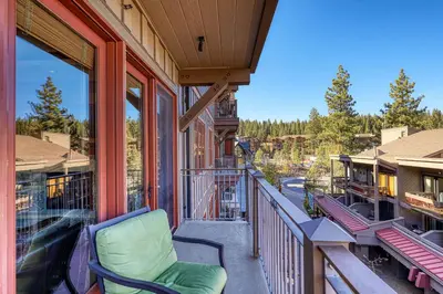 a balcony with a chair on a house at Iron Horse Lodge North 209 by East West Hospitality in Truckee