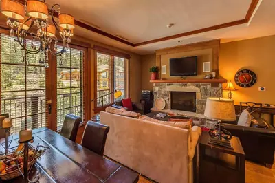 a living room with a table and a fireplace at Iron Horse Lodge South 406 by East West Hospitality in Truckee