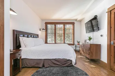 a bedroom with a bed and a dresser and a window at Iron Horse Lodge South 406 by East West Hospitality in Truckee