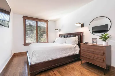 a bedroom with a large bed and a mirror at Iron Horse Lodge South 406 by East West Hospitality in Truckee