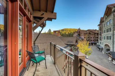 a balcony with a green chair on a building at Iron Horse Lodge North 310 by East West Hospitality in Truckee