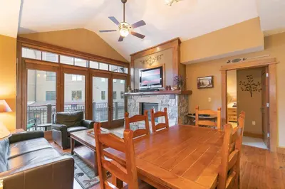 a dining room with a table and a fireplace at Iron Horse Lodge North 310 by East West Hospitality in Truckee
