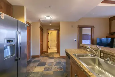 a kitchen with a stainless steel refrigerator and a sink at Iron Horse Lodge South 305 by East West Hospitality in Truckee