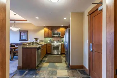 a kitchen with wooden cabinets and stainless steel appliances at Iron Horse Lodge South 305 by East West Hospitality in Truckee