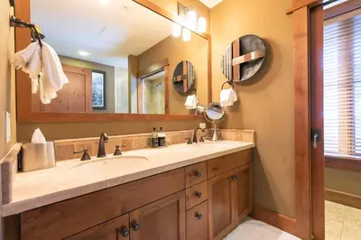 a bathroom with a sink and a large mirror at Iron Horse Lodge South 502 by East West Hospitality in Truckee