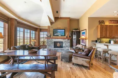 a living room with a table and a fireplace at Iron Horse Lodge South 502 by East West Hospitality in Truckee
