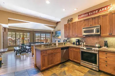 a large kitchen with wooden cabinets and a dining room at Iron Horse Lodge South 502 by East West Hospitality in Truckee