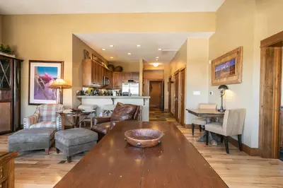 a living room with a table and a kitchen at Iron Horse Lodge South 502 by East West Hospitality in Truckee