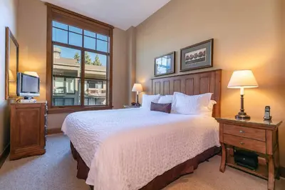 a bedroom with a large bed and a television at Iron Horse Lodge North 107 by East West Hospitality in Truckee
