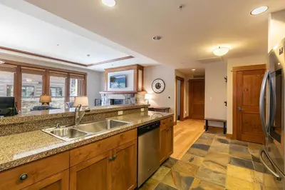 a kitchen with a sink and a refrigerator at Iron Horse Lodge North 206 by East West Hospitality in Truckee