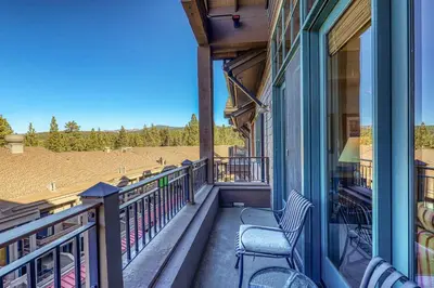a balcony of a house with two chairs on it at Iron Horse Lodge North 305 by East West Hospitality in Truckee