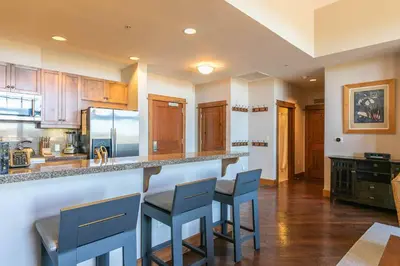 a kitchen with wooden cabinets and blue stools at Iron Horse Lodge North 305 by East West Hospitality in Truckee