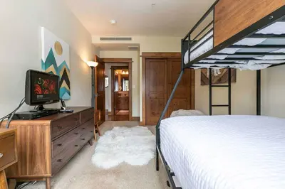 a bedroom with a bed and a bunk bed at Iron Horse Lodge South 404 by East West Hospitality in Truckee