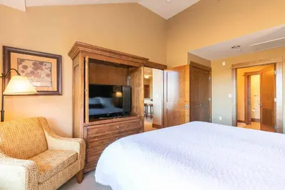 a bedroom with a bed and a flat screen tv at Iron Horse Lodge North 307 by East West Hospitality in Truckee