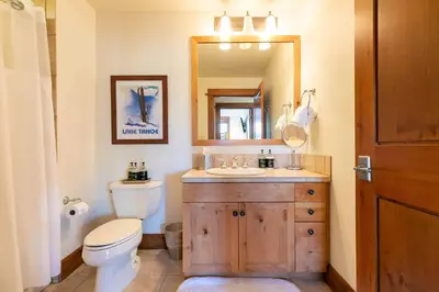 a bathroom with a toilet and a sink and a mirror at Iron Horse Lodge North 207 by East West Hospitality in Truckee