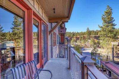 a balcony with a bench on a house with a view at Iron Horse Lodge North 207 by East West Hospitality in Truckee