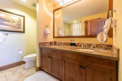 a bathroom with a sink and a toilet and a mirror at Iron Horse Lodge South 401 by East West Hospitality in Truckee