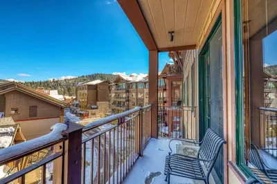 a balcony with a chair and a view of a city at Iron Horse Lodge South 401 by East West Hospitality in Truckee