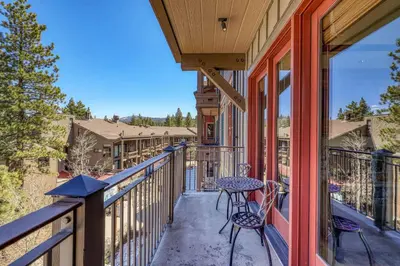 a balcony with a table and chairs on a house at Iron Horse Lodge North 201 by East West Hospitality in Truckee