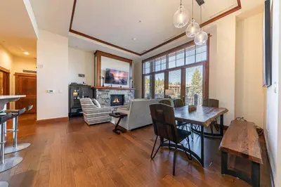 a living room with a table and a fireplace at Iron Horse Lodge North 103 by East West Hospitality in Truckee