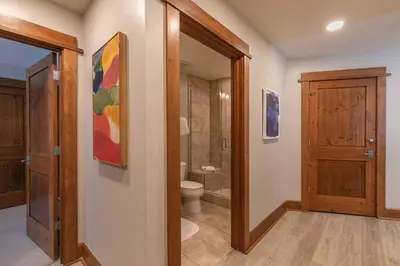a bathroom with a toilet and a shower and a door at Iron Horse Lodge South 308 by East West Hospitality in Truckee
