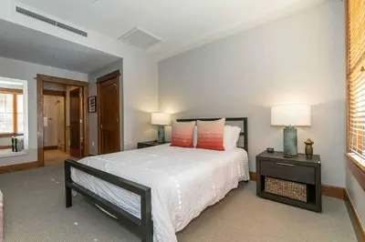 a bedroom with a bed and two lamps and a window at Iron Horse Lodge South 308 by East West Hospitality in Truckee