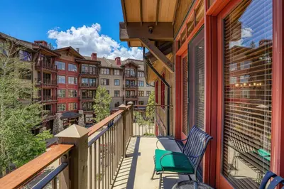 a balcony with chairs and a view of buildings at Iron Horse Lodge North 302 by East West Hospitality in Truckee