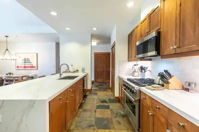 a kitchen with wooden cabinets and a stove top oven at Iron Horse Lodge North 302 by East West Hospitality in Truckee