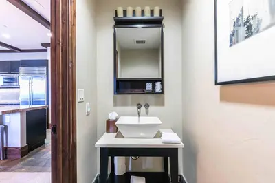 a bathroom with a sink and a mirror at One Village Place 502 by East West Hospitality in Truckee
