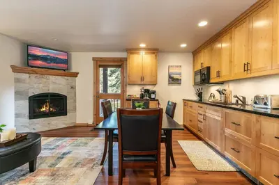 a kitchen with a table and a fireplace at Ski Trails 4119 by East West Hospitality in Truckee
