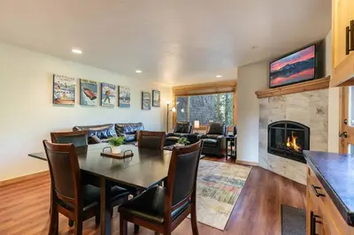a living room with a table and a fireplace at Ski Trails 4119 by East West Hospitality in Truckee