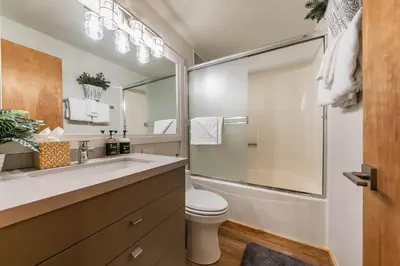 a bathroom with a toilet and a large mirror at Ski Trails 4115 by East West Hospitality in Truckee