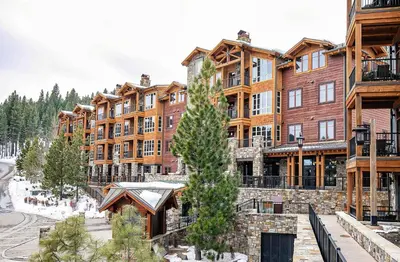 a large apartment building with a tree in front of it at Ski Trails 4115 by East West Hospitality in Truckee
