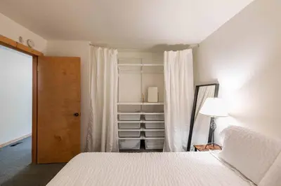 a bedroom with a white bed and a closet at Ski Trails 4099 by East West Hospitality in Truckee