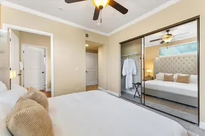 a bedroom with a large white bed and a mirror at 2BR Getaway Pool Gym Basketball Court & Theater Access in Reno