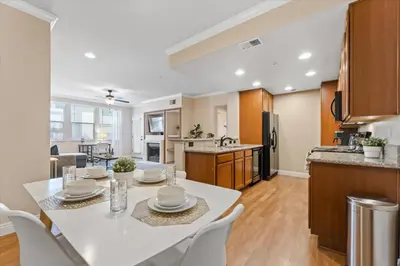 a kitchen and living room with a white table and chairs at 2BR Getaway Pool Gym Basketball Court & Theater Access in Reno