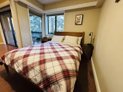 a bedroom with a bed with a plaid blanket at Knotty & Nice in Incline Village